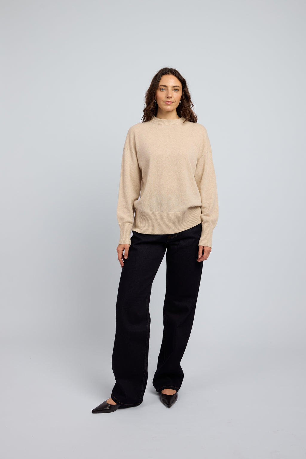 Woman wearing champagne cashmere crew sweater by Huntly styled with dark trousers, luxury lightweight cashmere knitwear Australia
