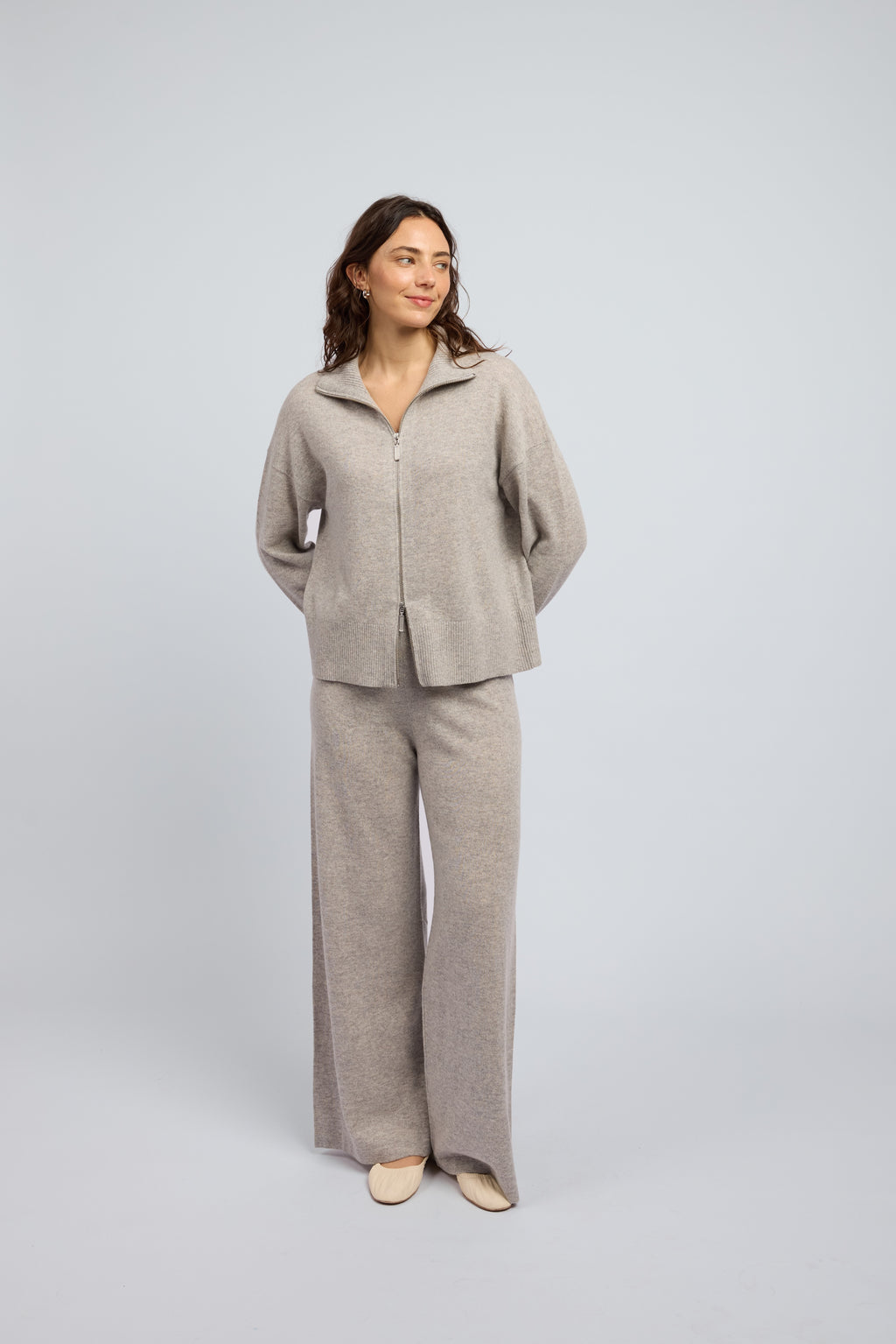 Woman wearing Margot Zip Jacket in Grey Marle, crafted from luxurious cashmere featuring a clean silhouette, double zip closure and soft structured collar