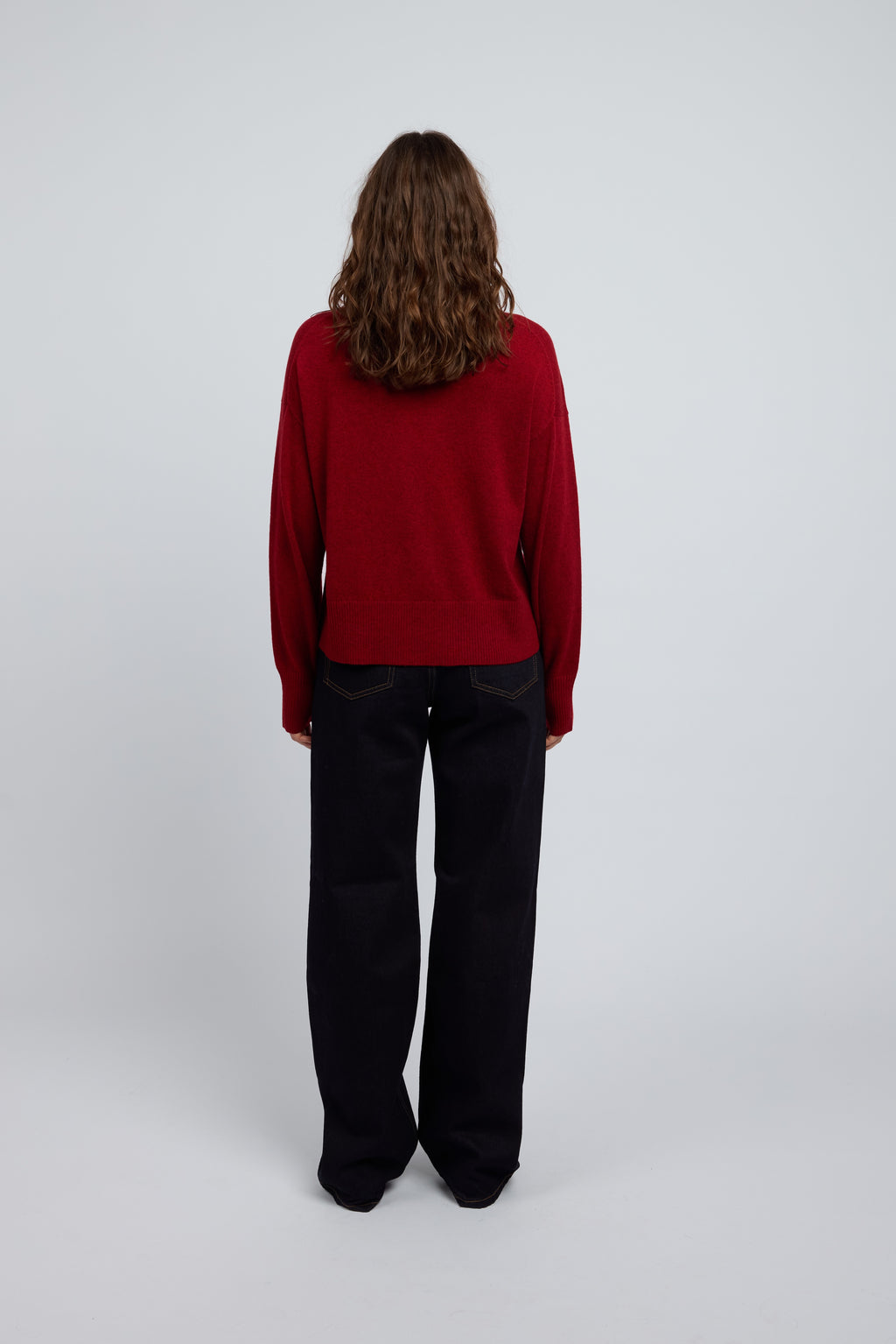 Woman wearing Margot Zip Jacket in Winecask Red, crafted from luxurious cashmere featuring a clean silhouette, double zip closure and soft structured collar