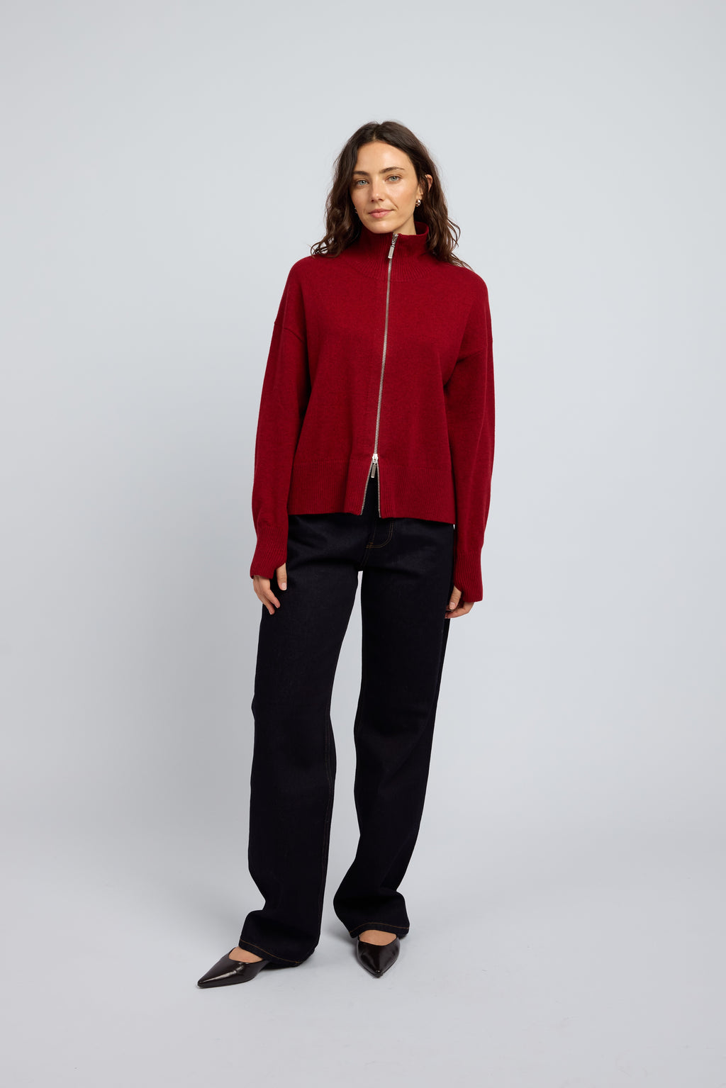 Woman wearing Margot Zip Jacket in Winecask Red, crafted from luxurious cashmere featuring a clean silhouette, double zip closure and soft structured collar