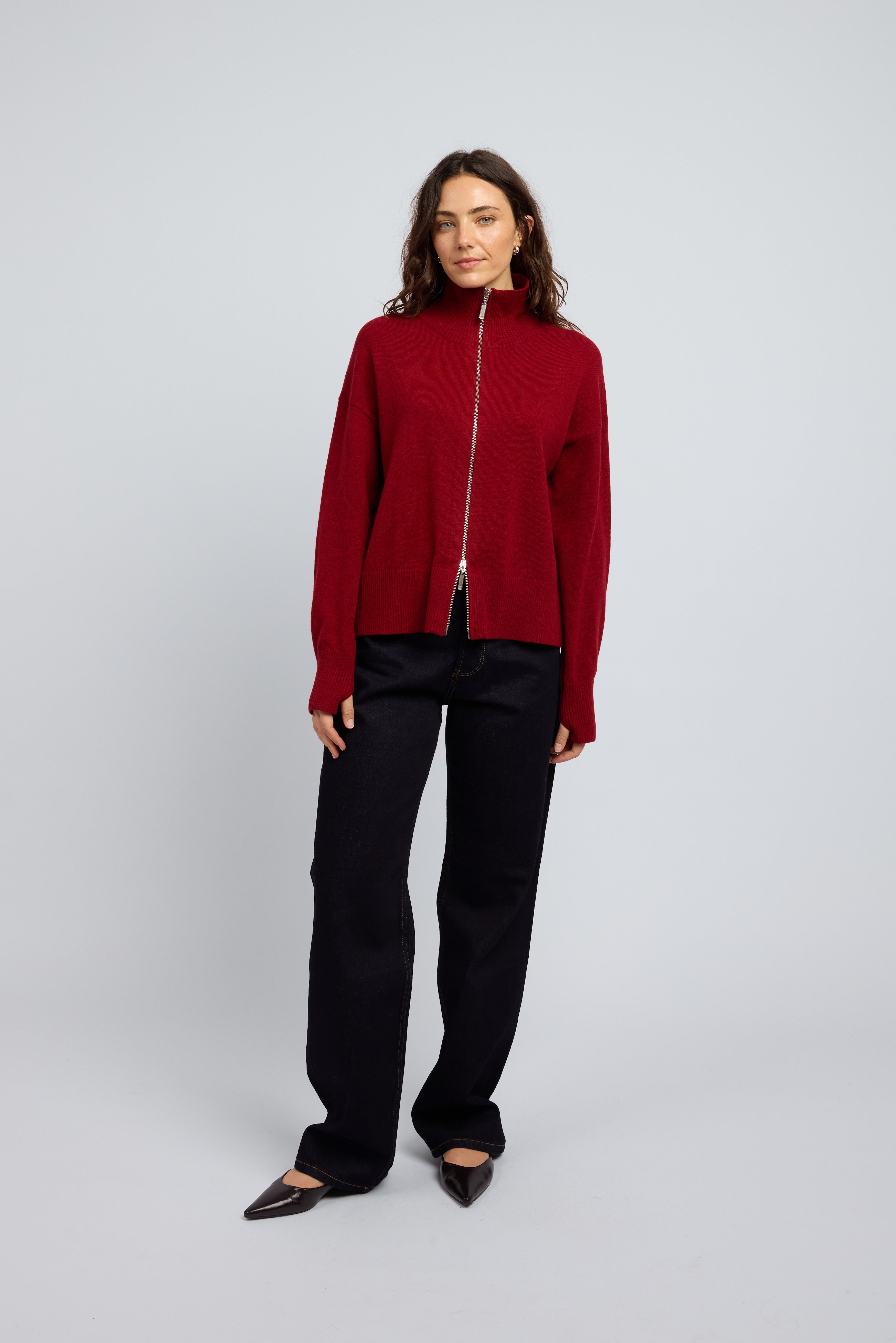 Woman wearing Margot Zip Jacket in Winecask Red, crafted from luxurious cashmere featuring a clean silhouette, double zip closure and soft structured collar
